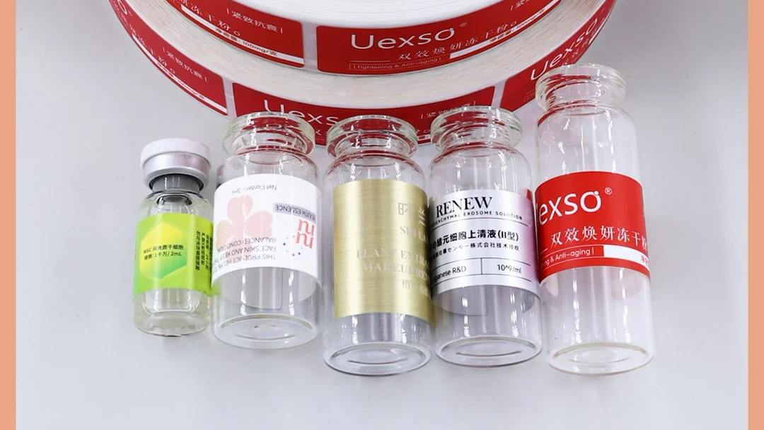 Display of custom vial label samples featuring various materials, colors, and sizes
